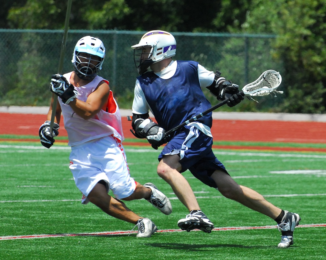 Two male athletes playing a lacrosse game