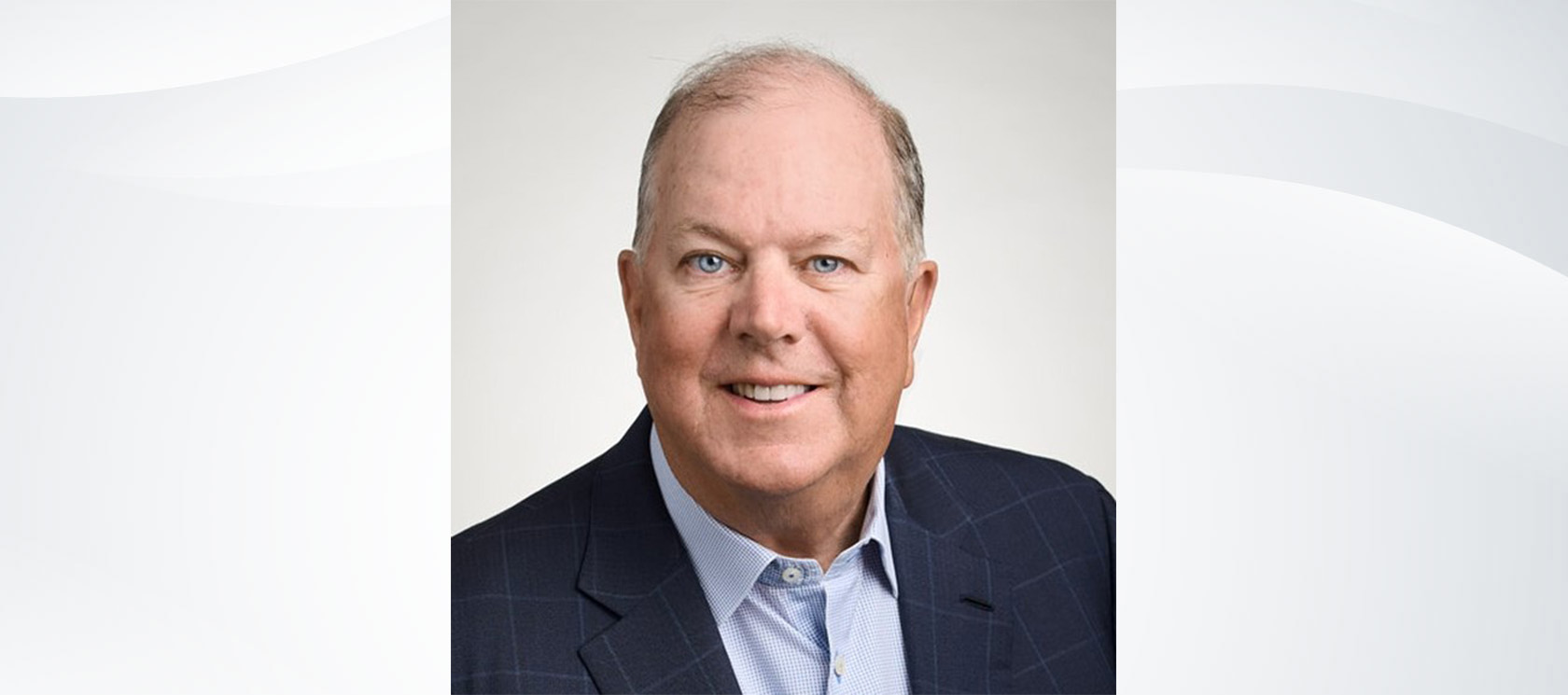 Headshot of Alan McKim on a gray wave-patterned background