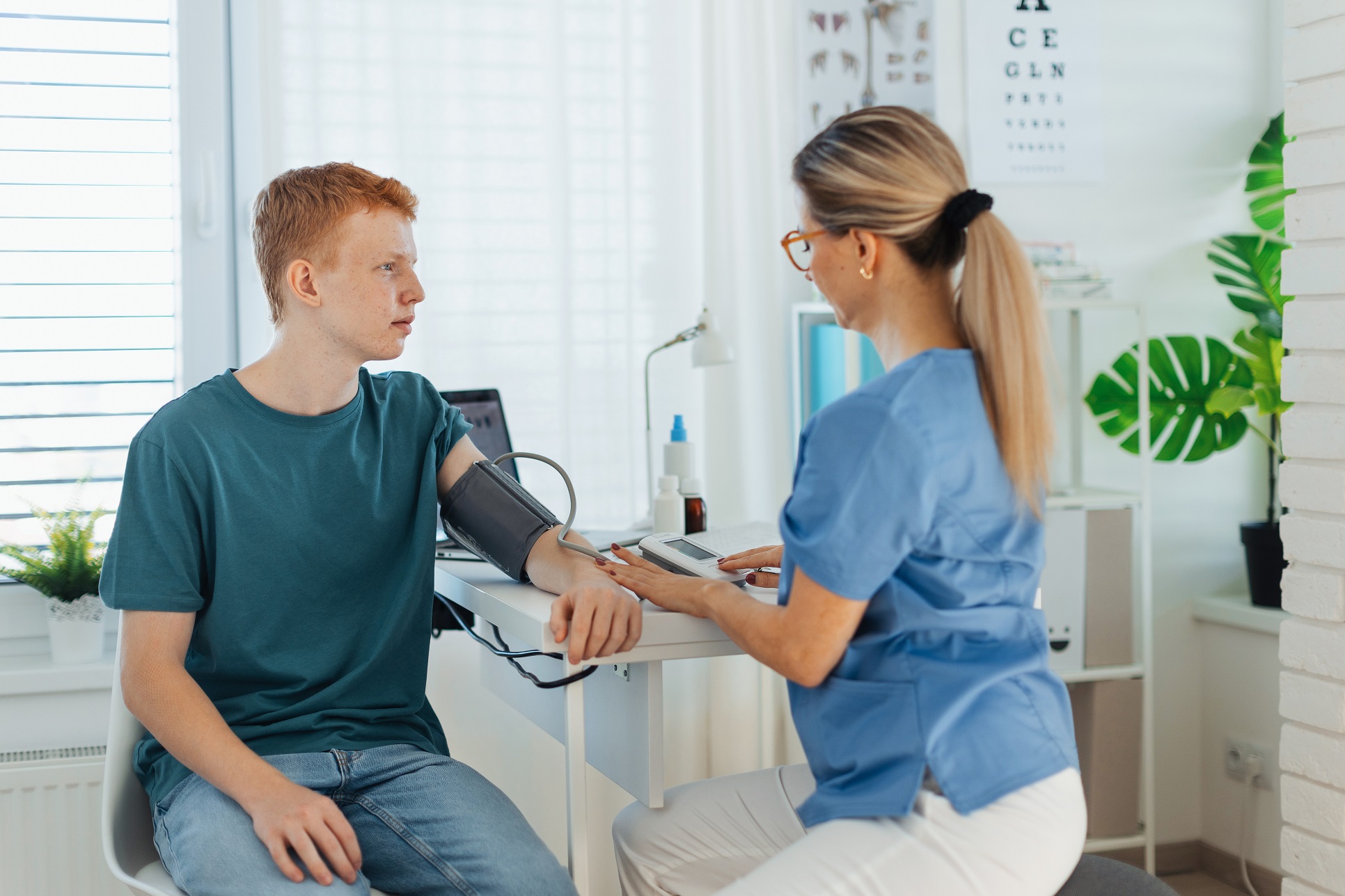 A male student athlete has his blood pressure checked during a sports physical