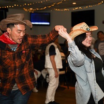 Two guests in western attire dance at a recent Kickin' Up Country event