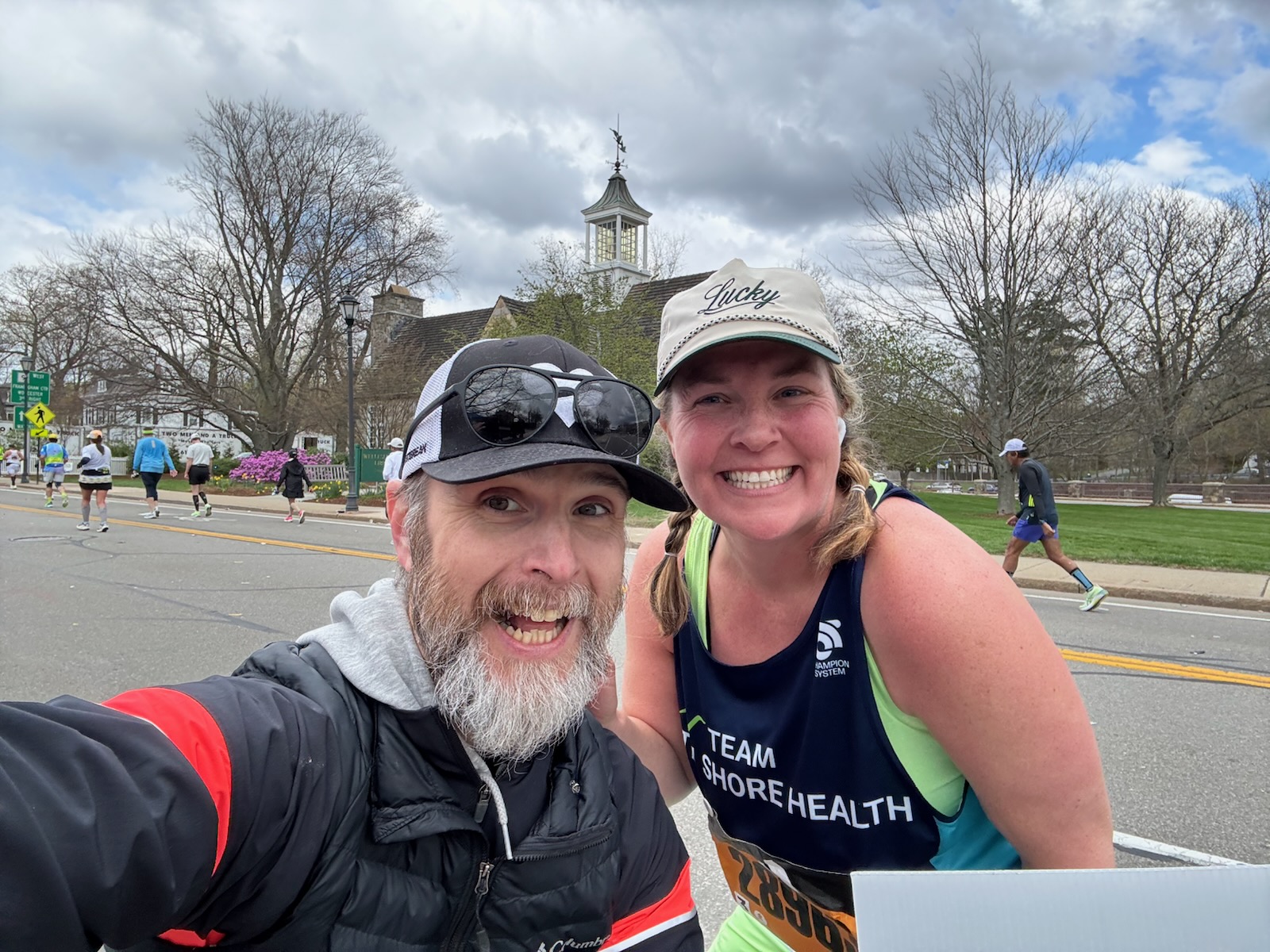 Lindsay of Team South Shore Health stops to take a photo with Jay along the 2026 Boston Marathon route.