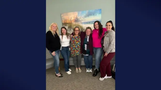 Photo of CCU colleagues from South Shore Health posing for a group shot on a navy background