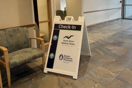 Check in sign at South Shore Medical Center Norwell with South Shore Medical Center and Boston Children's Physicians Norwell logos