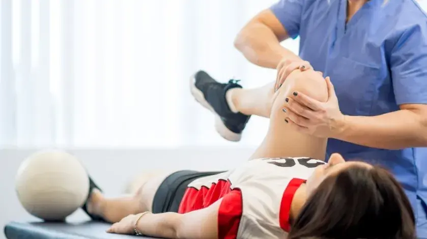 A provider evaluates the knee of an injured athlete