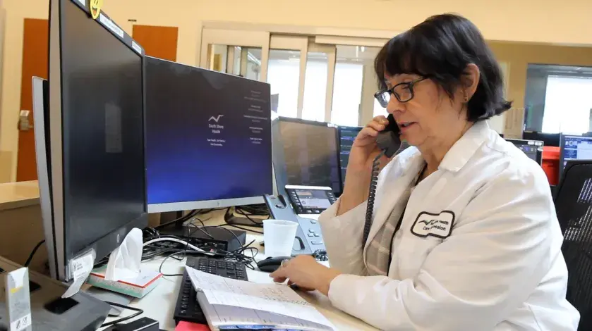 Trish from Care Progression sits at her desk on the phone at South Shore Hospital