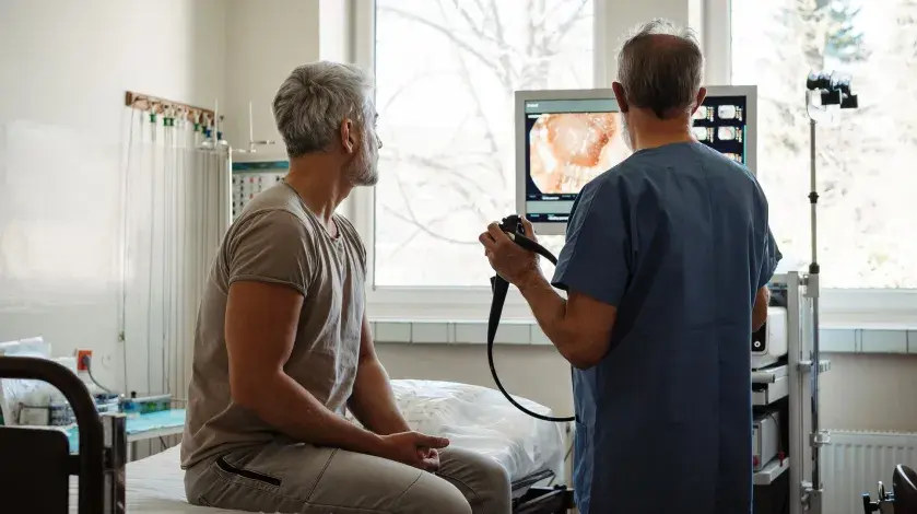 A provider goes over initial colonoscopy results with a male patient