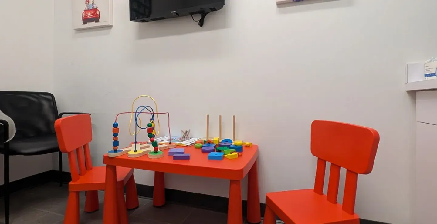 View of a kids table and chairs, with toys and puzzles on it, at South Shore Health Urgent Care Braintree