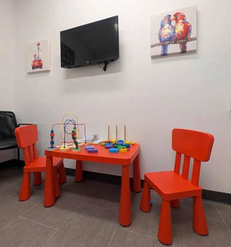 View of a kids table and chairs, with toys and puzzles on it, at South Shore Health Urgent Care Braintree