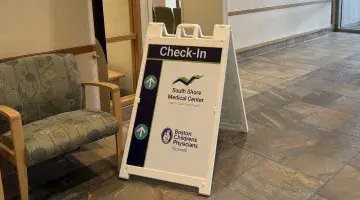 Check in sign at South Shore Medical Center Norwell with South Shore Medical Center and Boston Children's Physicians Norwell logos
