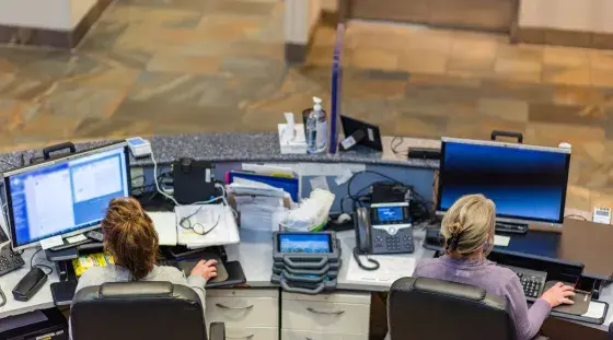 An overhead look at the registration desk at SSMC Norwell, with two receptionists seated at computers